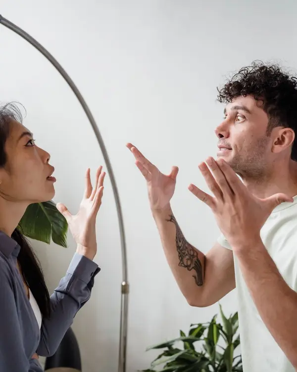 Casal em discussão acalorada, gesticulando