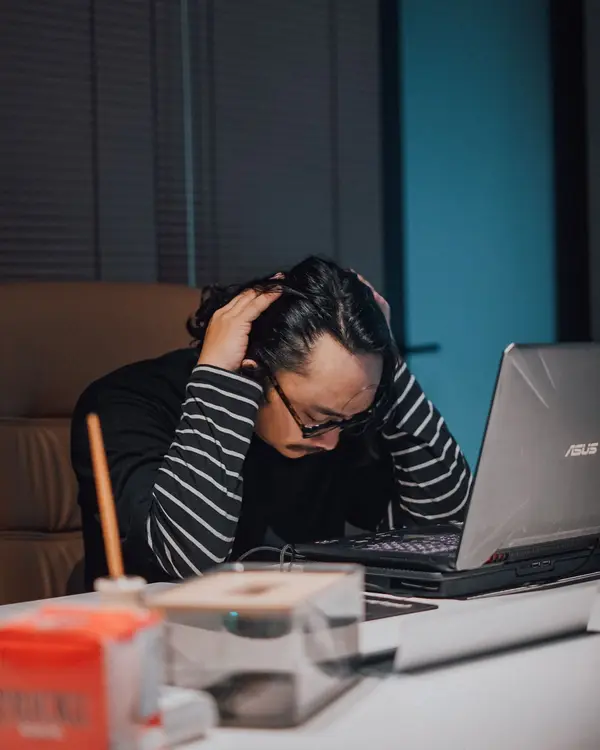 Homem exausto trabalhando no computador até tarde